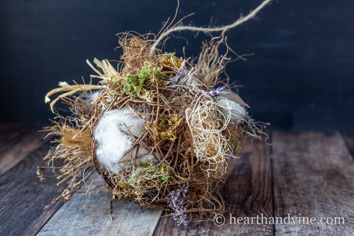 A nesting materials ball for birds showing coco fiber, wool, moss, raffia, and more.