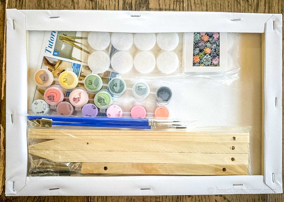 Items from the paint by number kit tucked into the back of the painting frame.