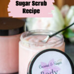 A jar of sugar scrub with the lid leaning on it.