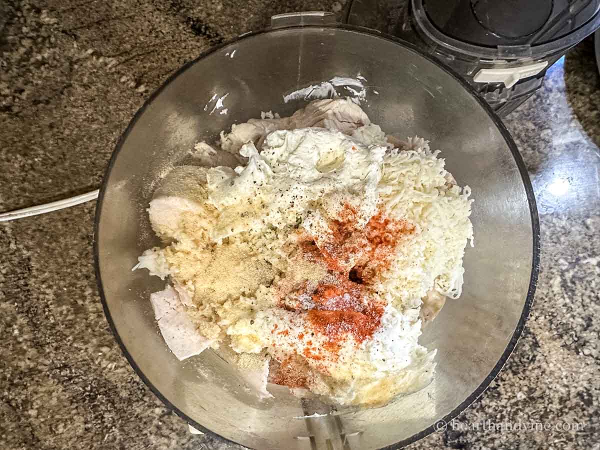 Cooked chicken, mozzarella, cream cheese and spices in a food processor.