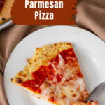 A fork taking a bite of a slice of chicken parm pizza.