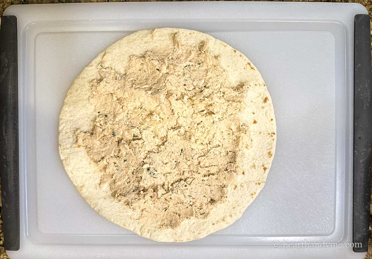 Chicken spread mixture spread onto a tortilla.