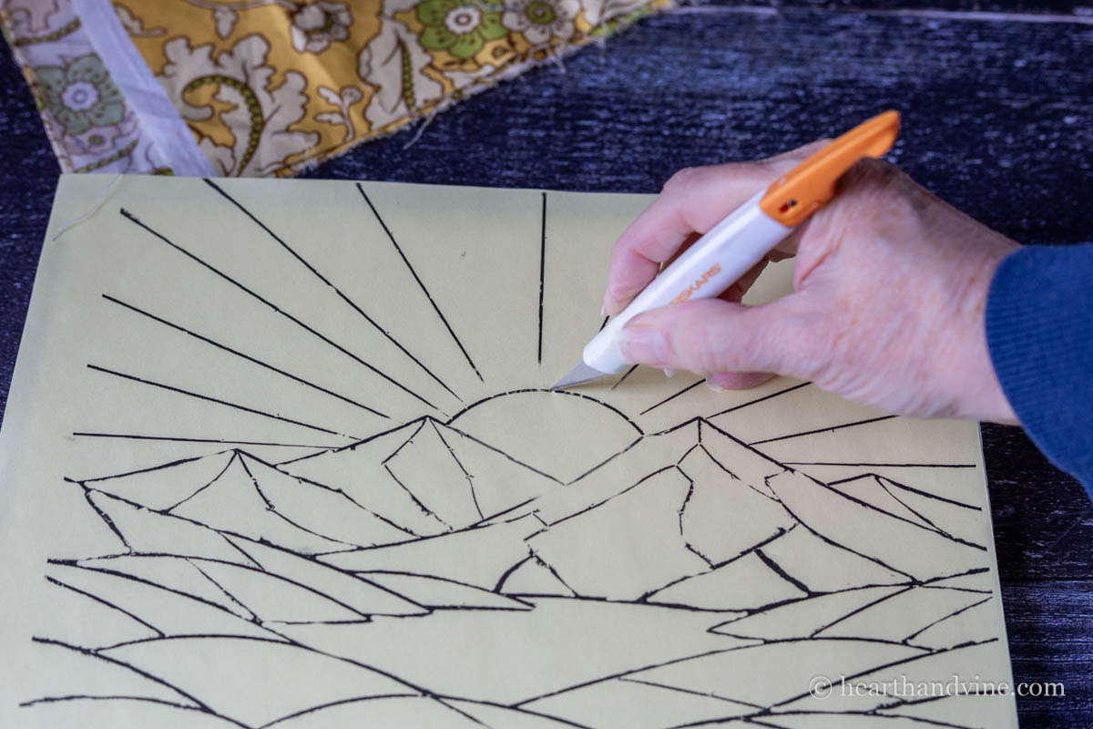 An Xacto knife cutting out a section of the template drawing.