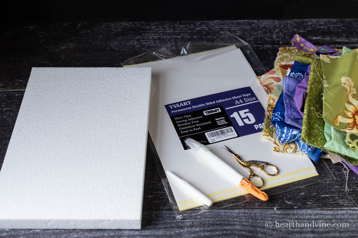 Kinusaiga art supplies including foam boards, adhesive paper, fabric in several colors, an xacto knife, small scissors, and a seam ripper.