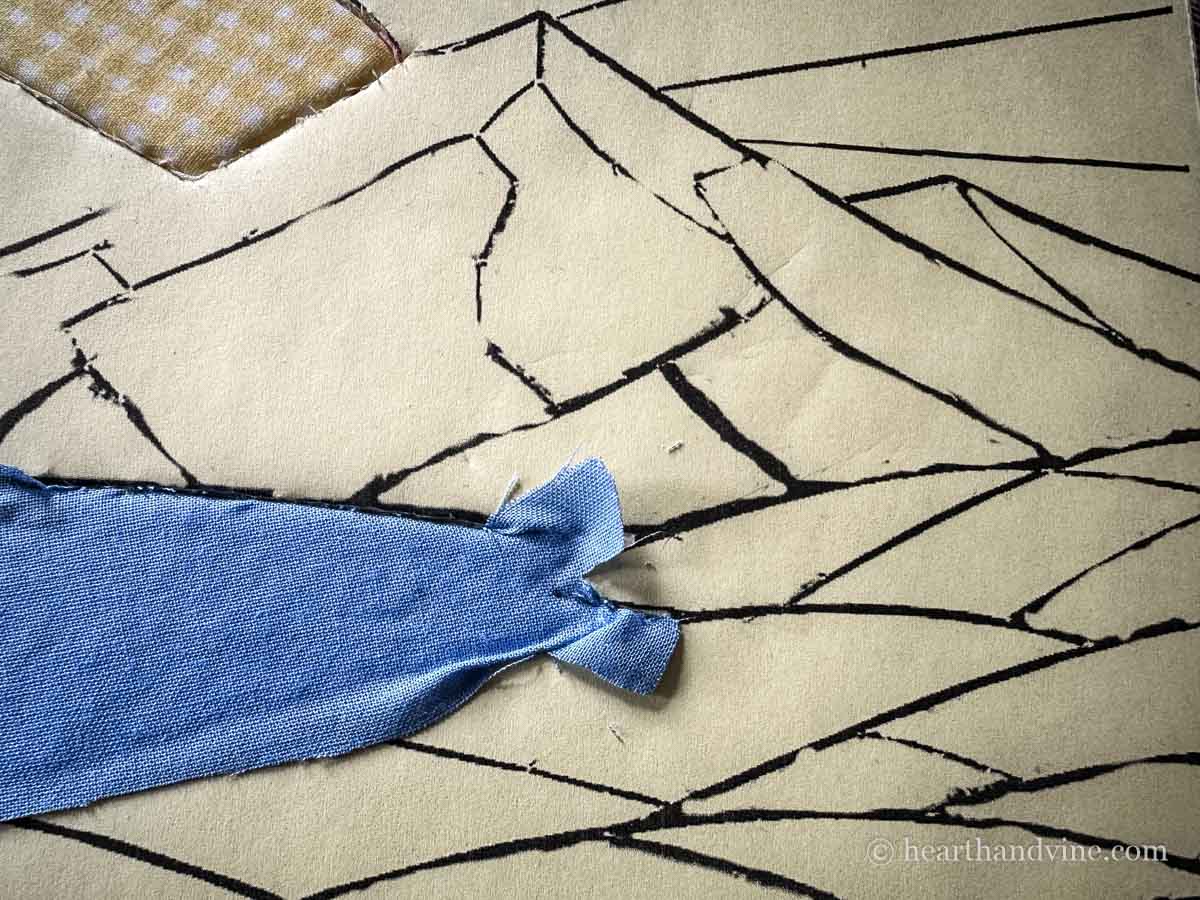 Another section of the image with a new piece of fabric partially punched into the foam board.