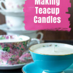 A blue teacup candle in front of a stack of other teacup candles.