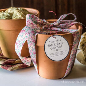 Two clay pots to make flower pot bread. One in front with ribbon and tag.