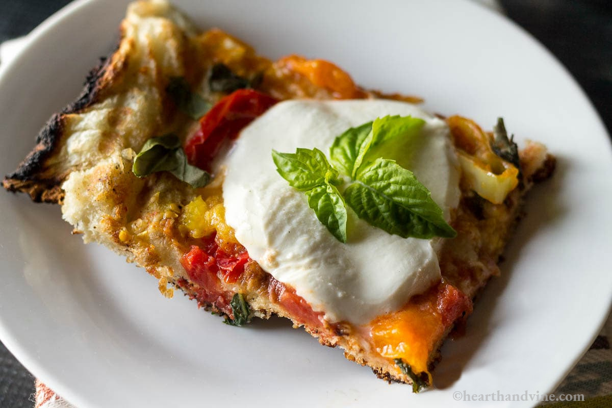 Slice of grilled pizza with fresh basil.