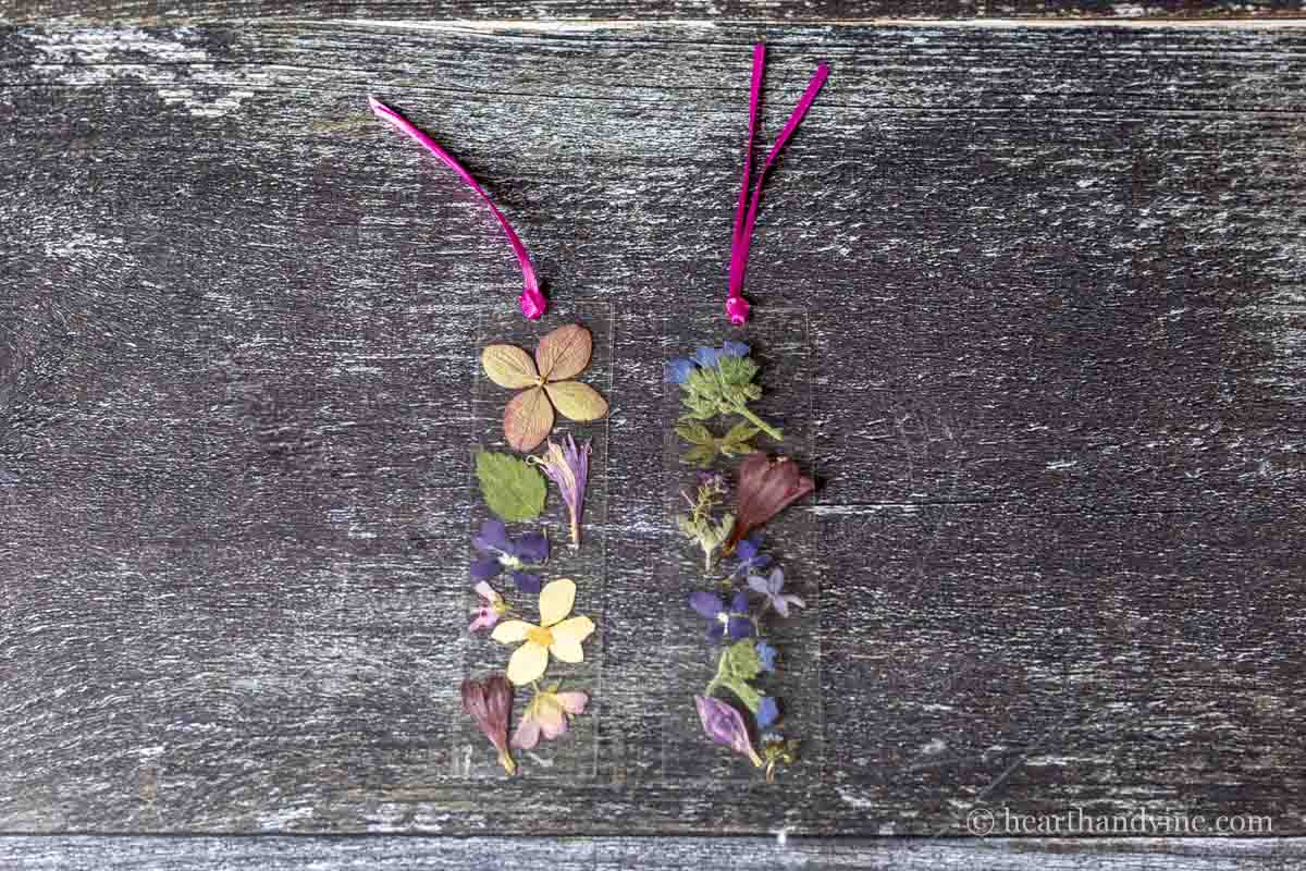 Two pressed flower bookmarks made with laminating sheets and pink ribbon.