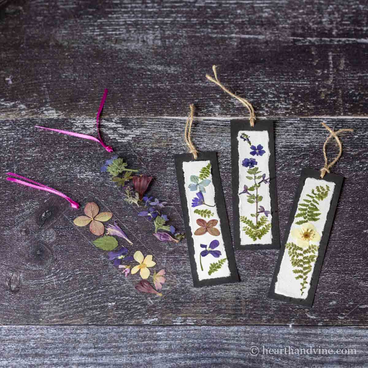 Five pressed flower bookmarks. Three on paper and two with plastic lamination sheeting.