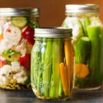 Trio of pickled vegetables in mason jars.