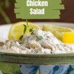 Side view of lemon chicken salad in a bowl with lemon slices.