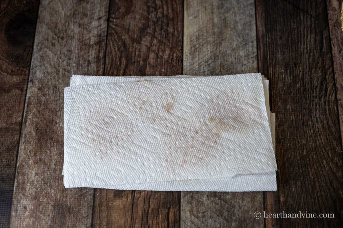 Parmesan cheese crisps between sheets of paper towel.