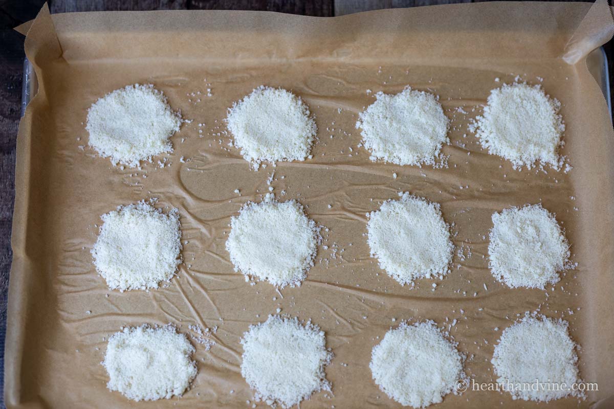Flatten mounds of parmesan cheese on parchment.