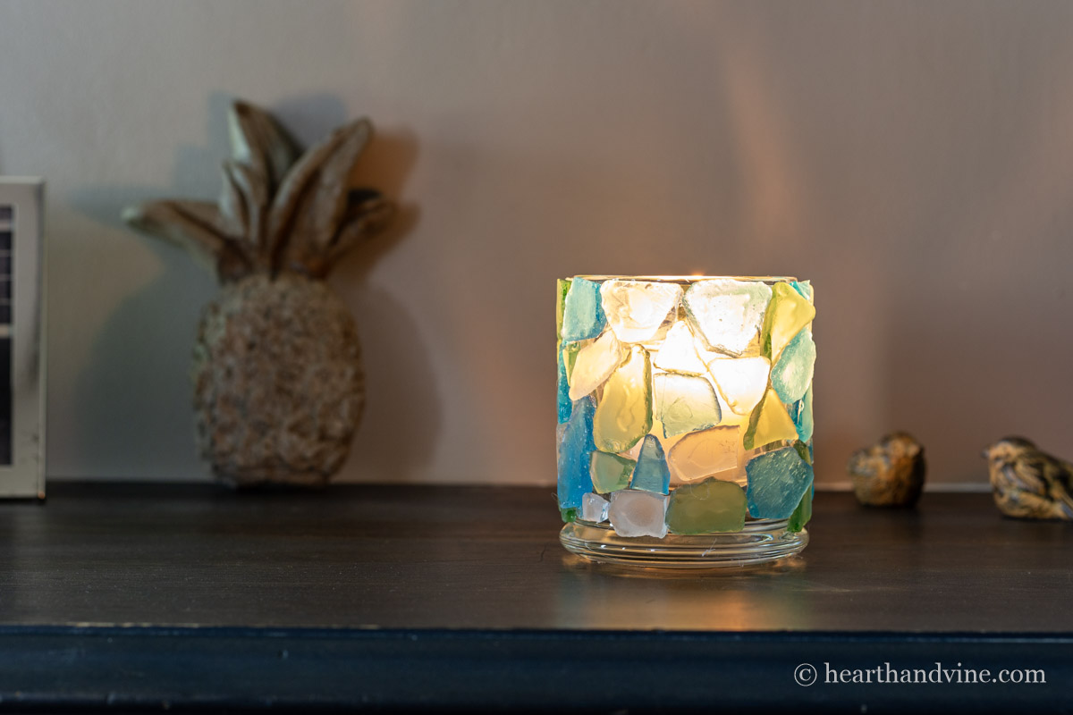 Sea glass candle holder lit in the dark.