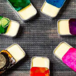 A circle of solid perfume tins in various colors.