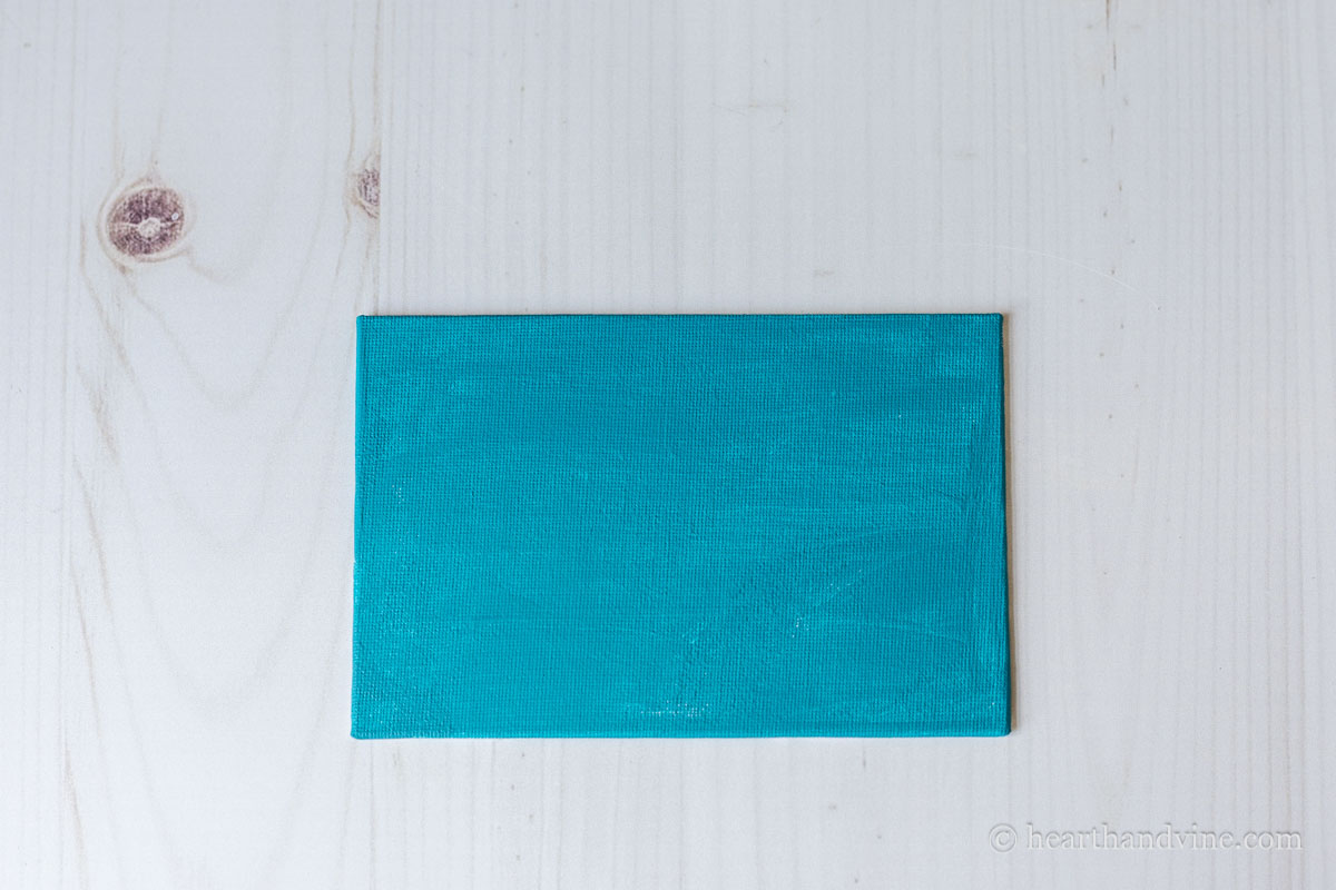 Canvas board painted blue.
