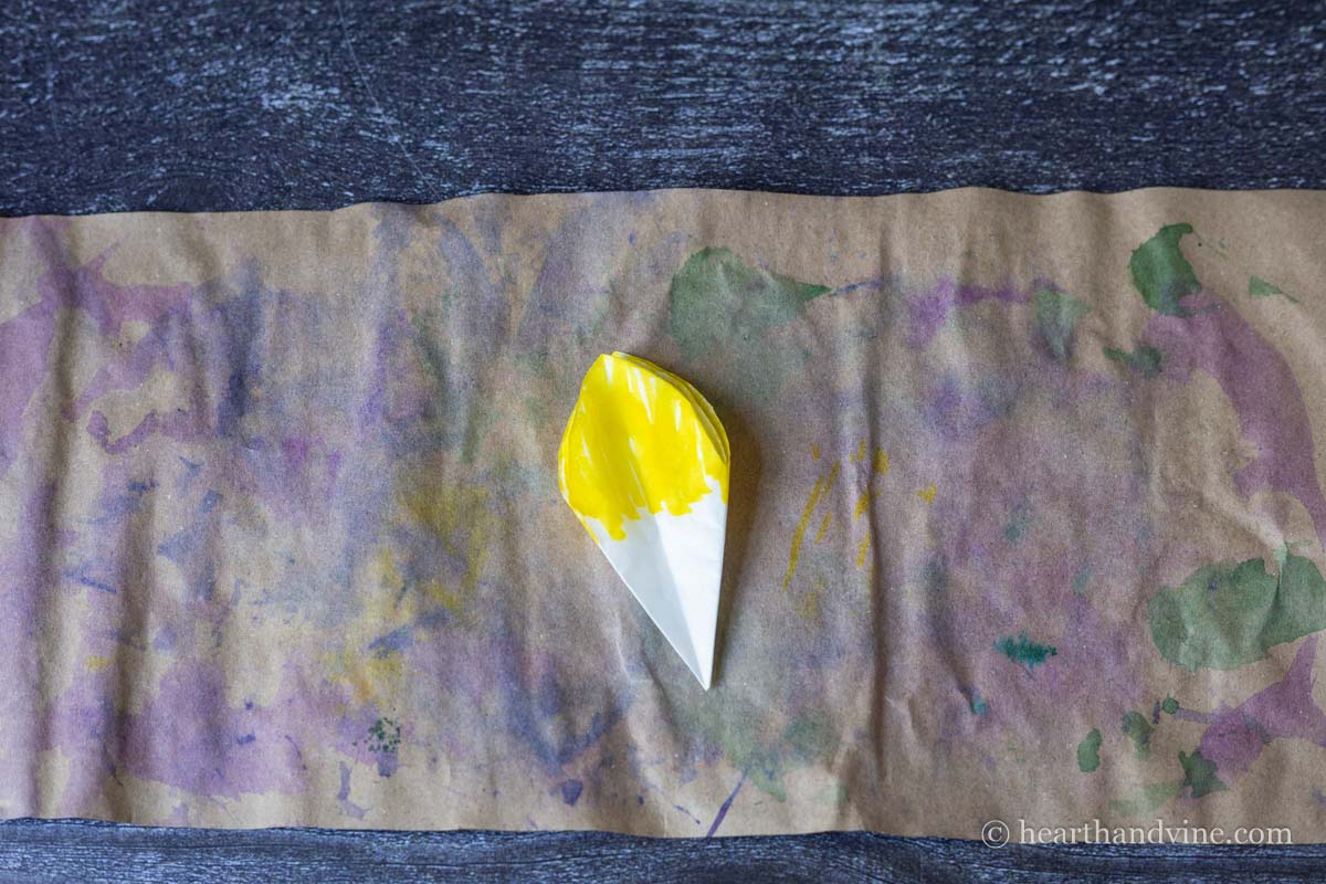 Top of folded coffee filter colored in yellow.