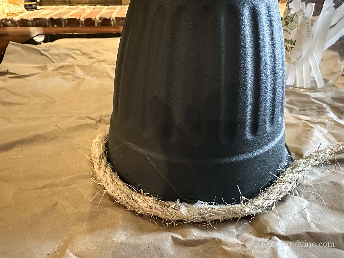Sisal rope glued to the edge of a pot turned upside down.
