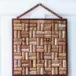 A handmade wine cork hanging board on a white door.