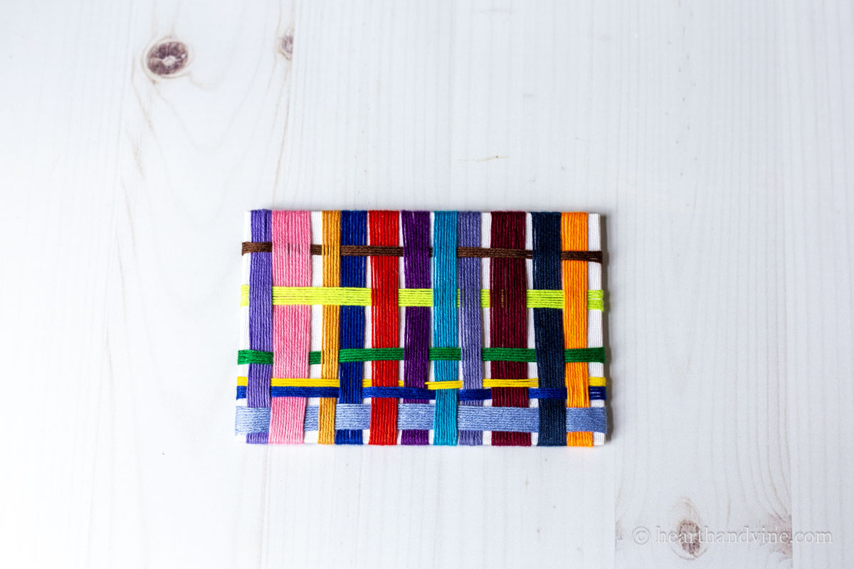Off loom weaving project with a unpainted white background.