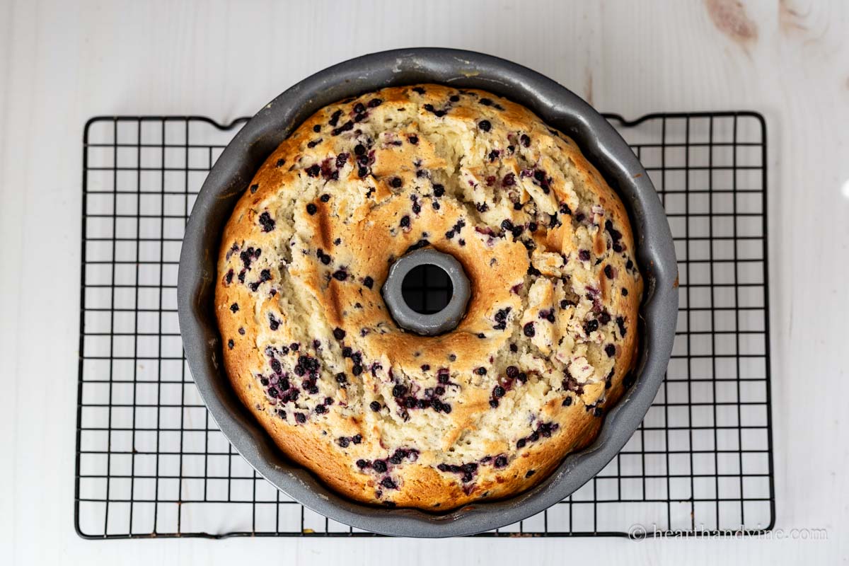 Blueberry and lemon bundt cake cooking on a wire rack.