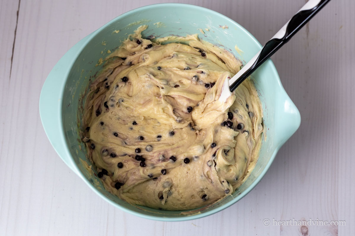 Bundt cake batter with some berries and a rubber spatula.