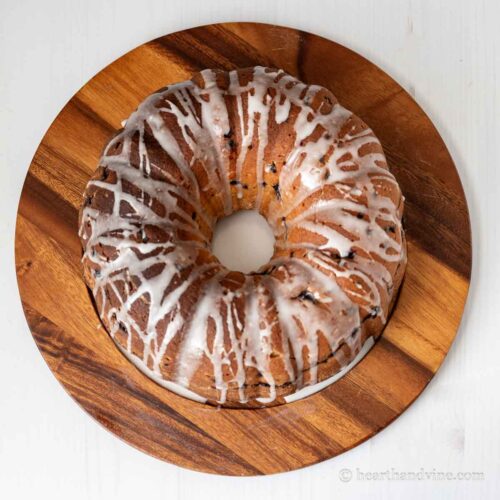 Blueberry and lemon bundt cake on a wooden platter.