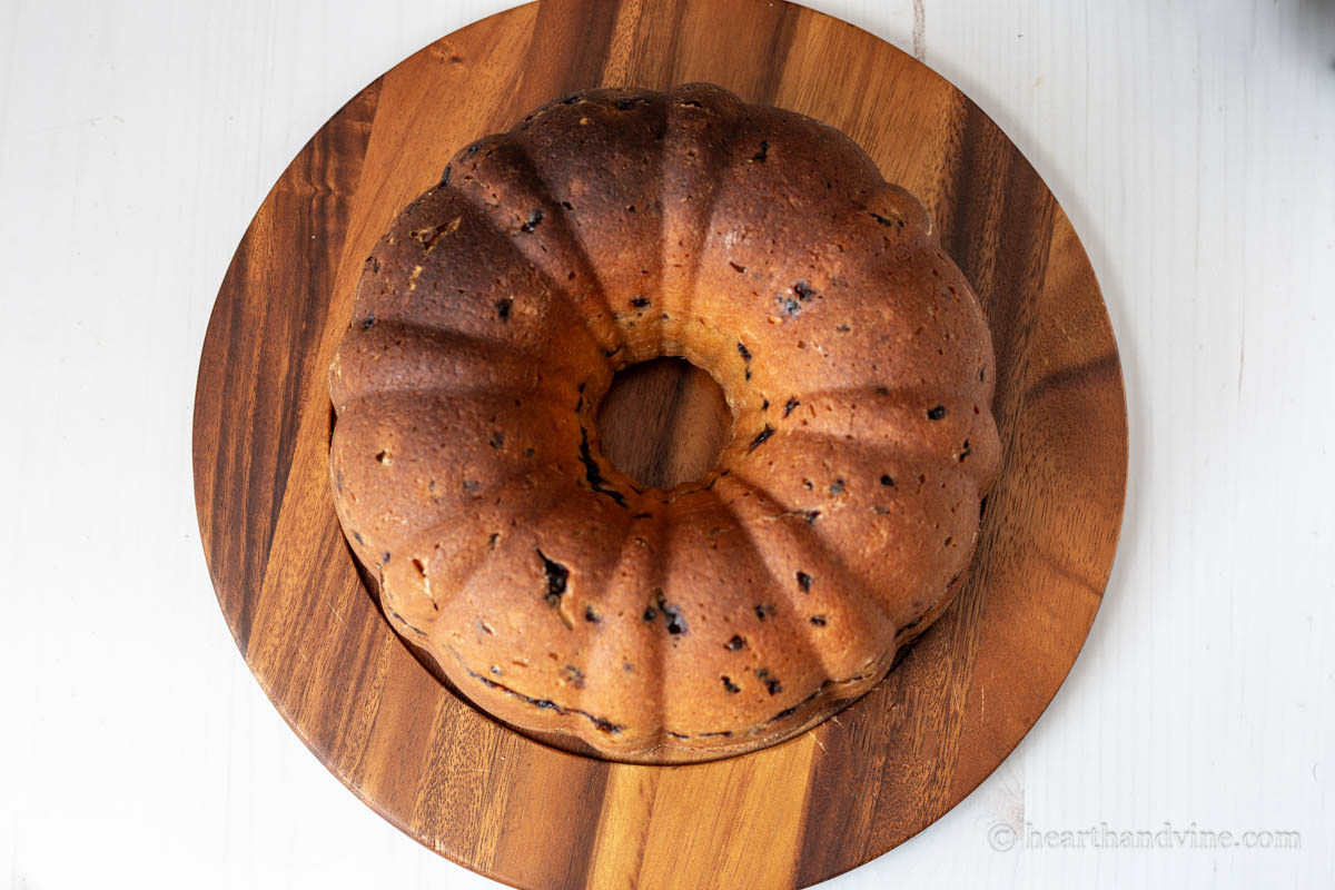 Blueberry and lemon bundt cake on a wooden platter before lemon glaze.