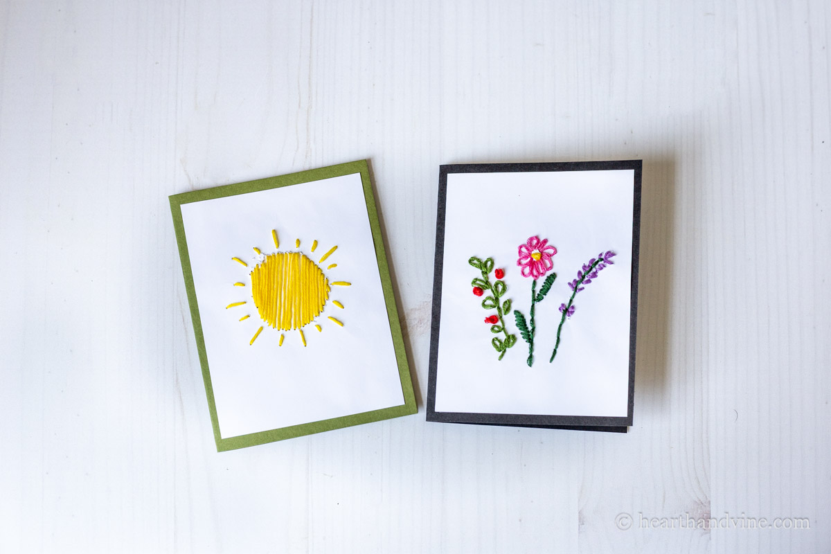 Two finished card embroidery projects. One of a sun and one of flowers.