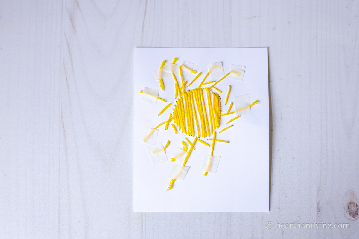 Back of card embroidered with a sun design.