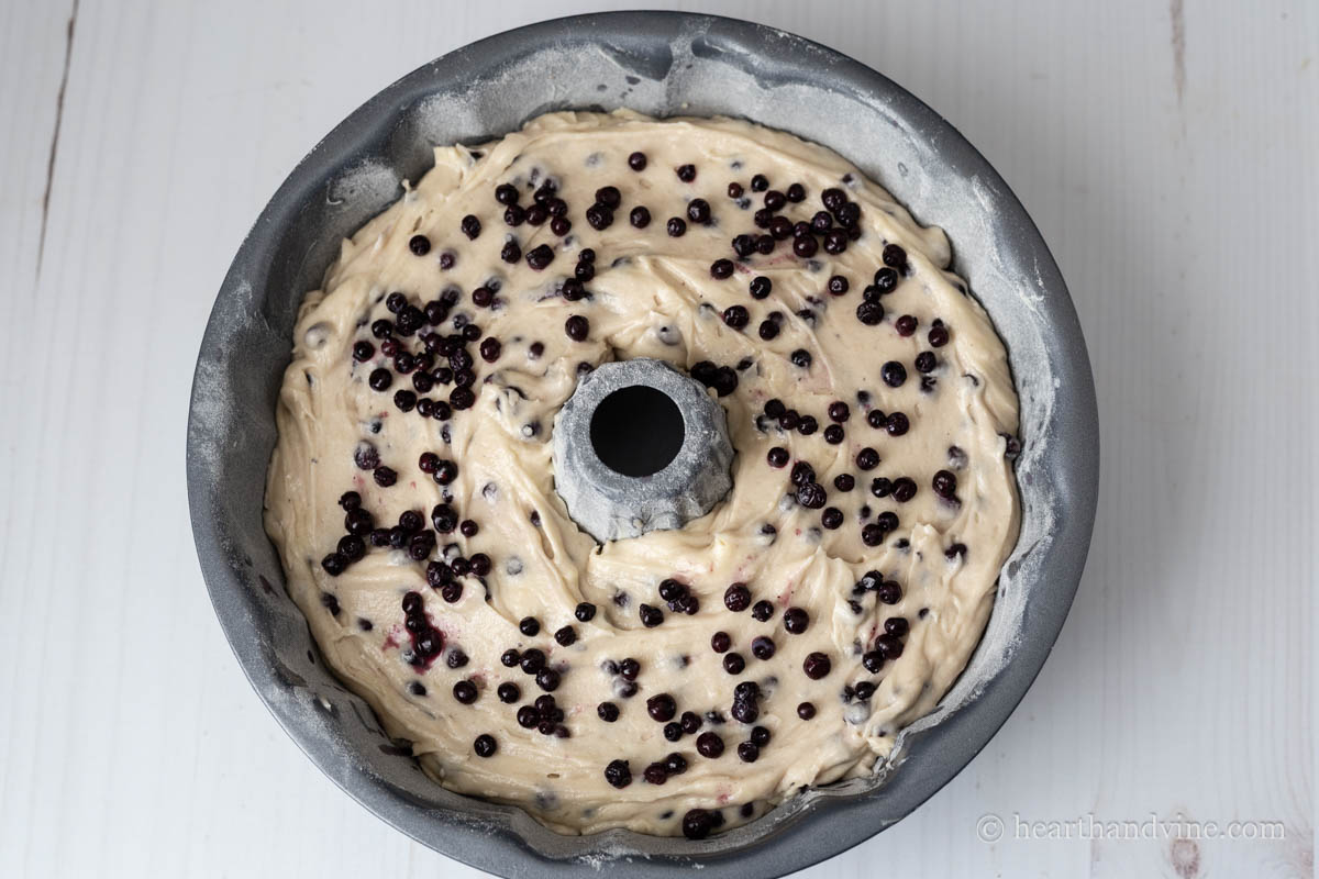 All of the batter in the bundt pan with a few more berries placed on top.