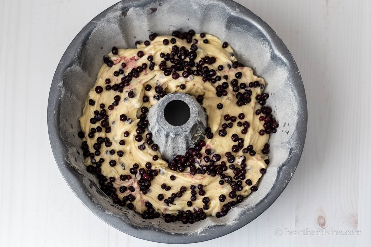 Half of the batter in the prepared pan with more blueberries scattered on top.