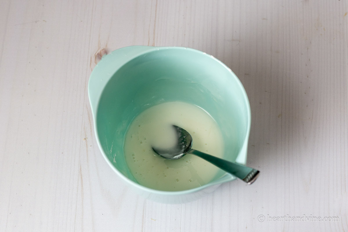 Lemon glaze in a mixing bowl with a spoon.