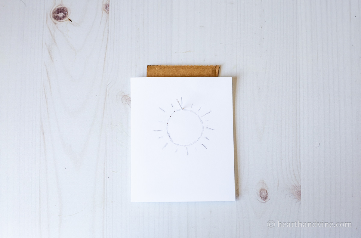 Poking holes into card design on top of a piece of cardboard.