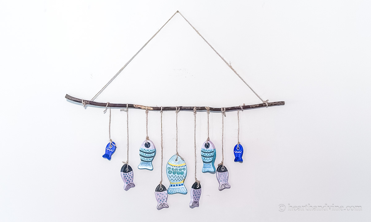 A colorful clay fish wall hanging on a wall.