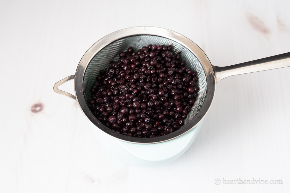 Defrosted wild blueberries in a strainer.