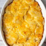 Vertical aerial view of potatoes au gratin in an oval dish.