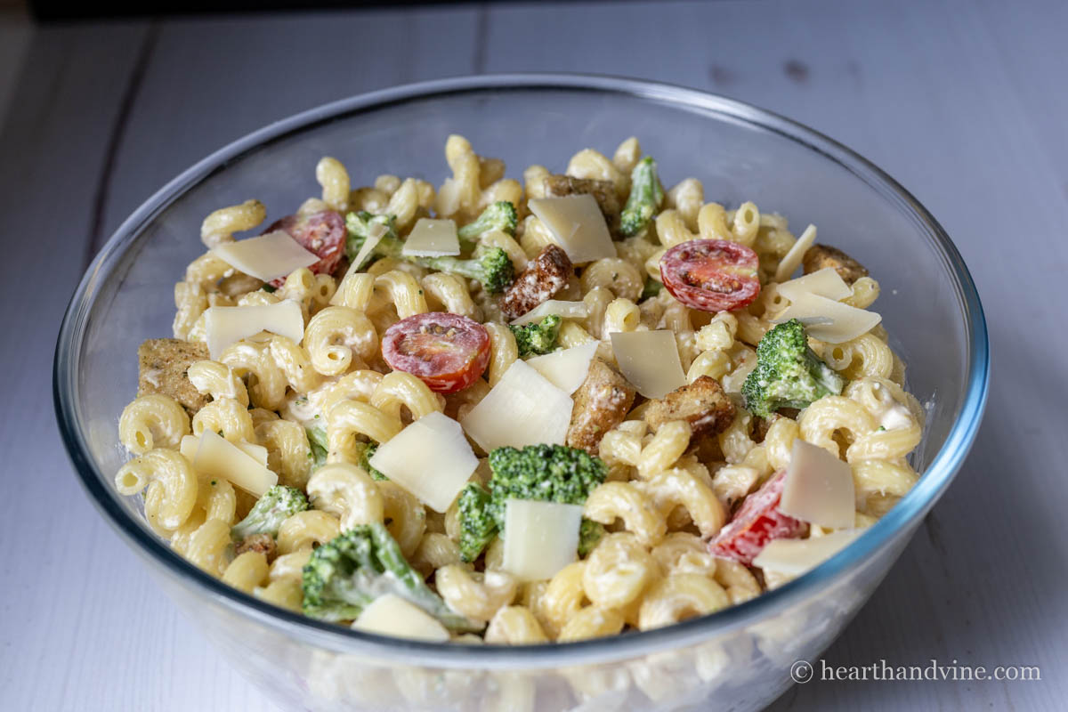 Large clear bowl with Caesar pasta salad.
