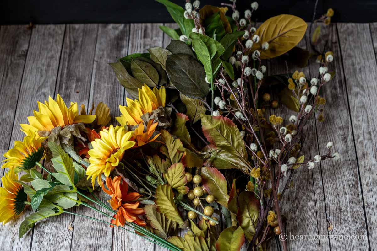 Grouping of artificial sunflowers and mixed greenery.