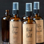 Amber spray bottles with kraft paper labels of homemade room sprays.