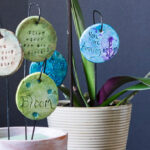 Different plant charms with sayings set in pots.