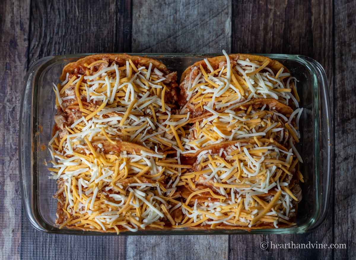 Filled hard taco shells topped with shredded cheese.