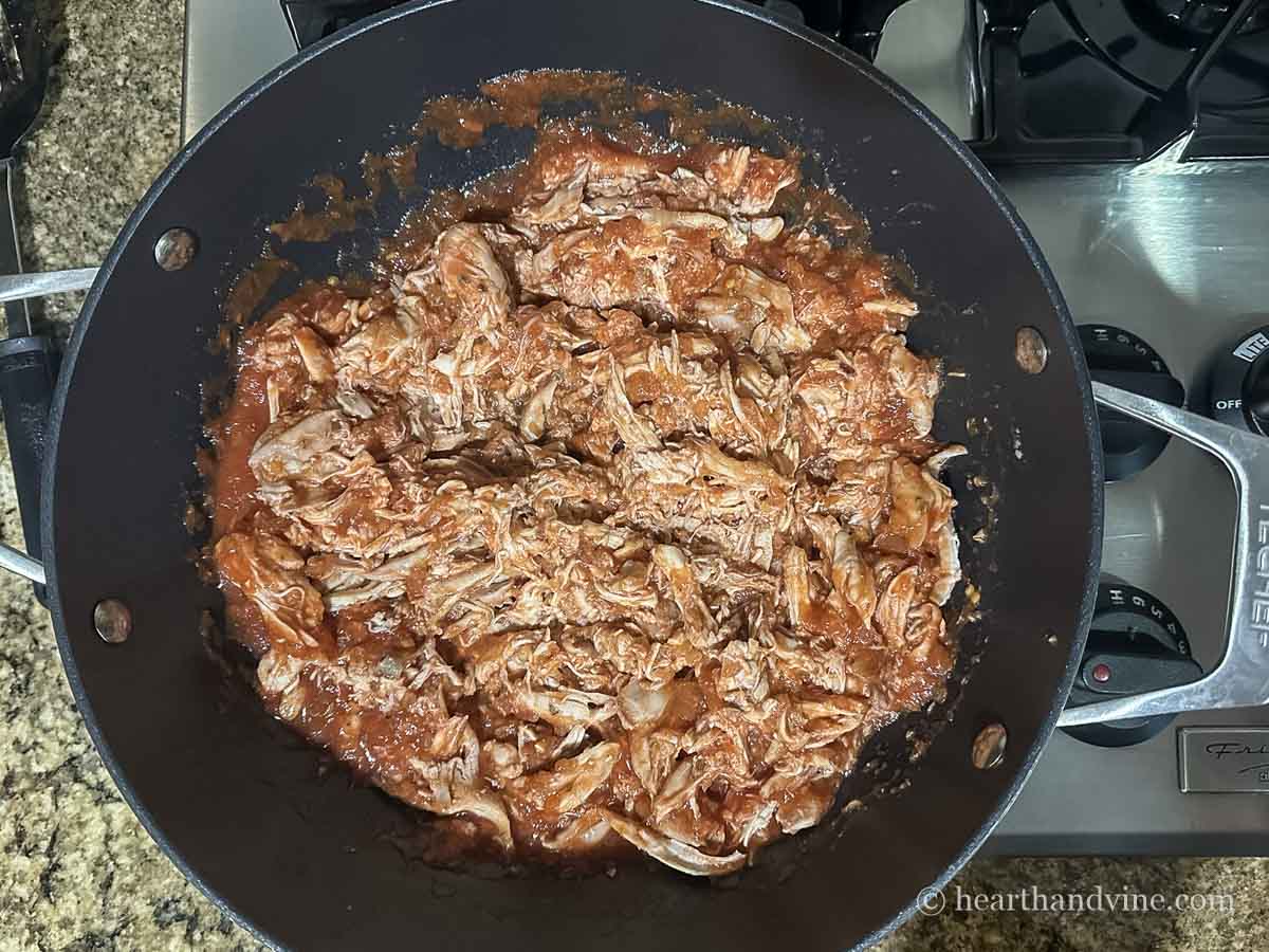 Shredded chicken added to sauce.
