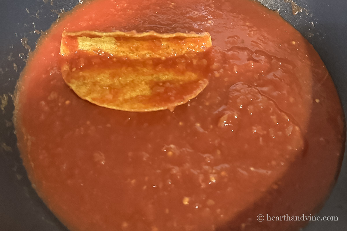Hard shell taco dipped into salsa mix.