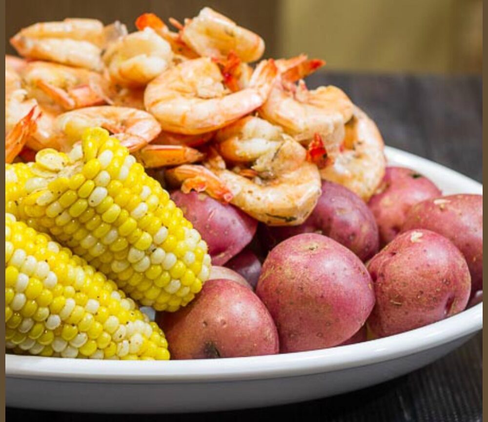Platter with shrimp, corn and potatoes.