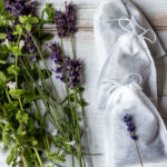 Herbal dream pillows in a line with herbs of lavender and lemon balm on the side.