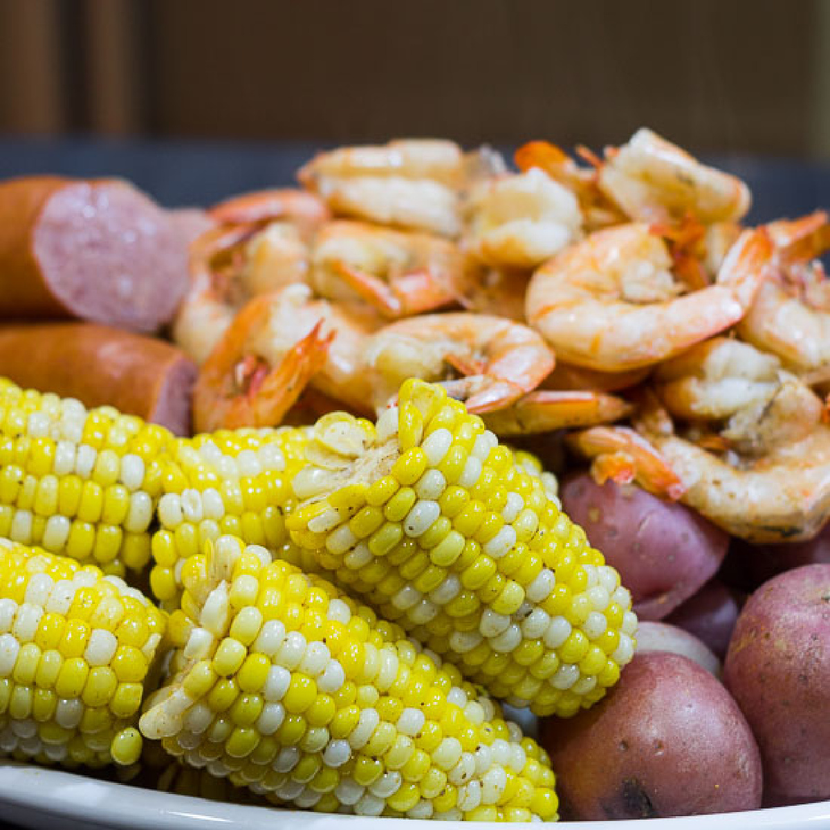 One-Pot-Shrimp-Boil Platter with shrimp boil including corn on the cob, shrimp, red potatoes and kielbasa.