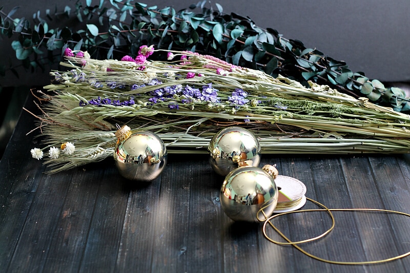 Dried flowers and eucalyptus stems, gold cording and gold Christmas balls.