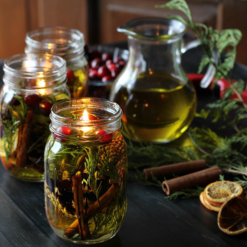 Mason Jar Oil Candle Lamps, pitcher of olive oil, cranberries, cedar, cinnamon sticks and orange slices.